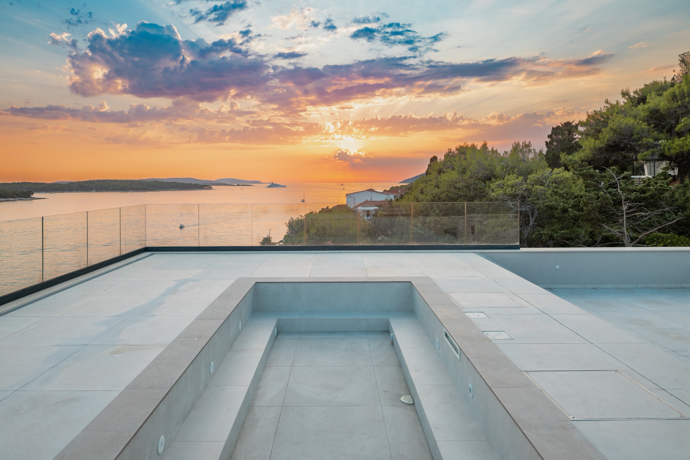 Roof terrace of Villa Infinity at dusk above the bay